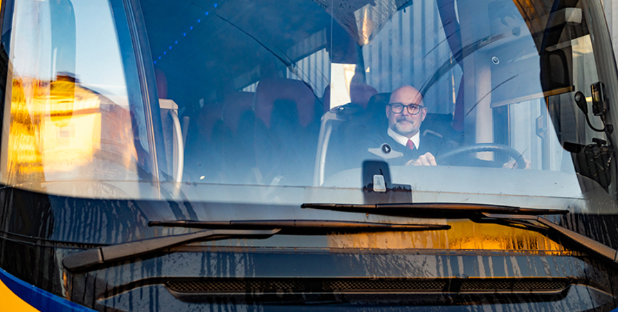 Bussförare Nisse bakom ratten i sin buss