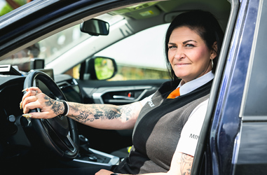 Taxiförare Carin Ahlfeldt bakom ratten i sin taxibil