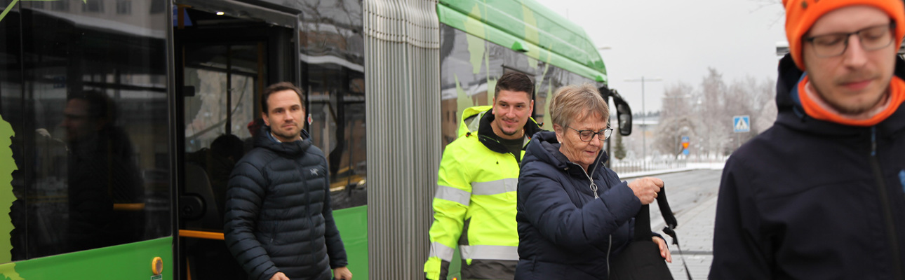 Resenärer kliver av en buss genom bakre dörren