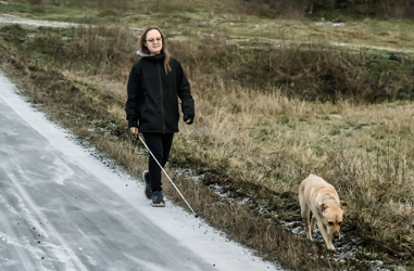 Bussresenär Sofia med sin vita käpp och hund
