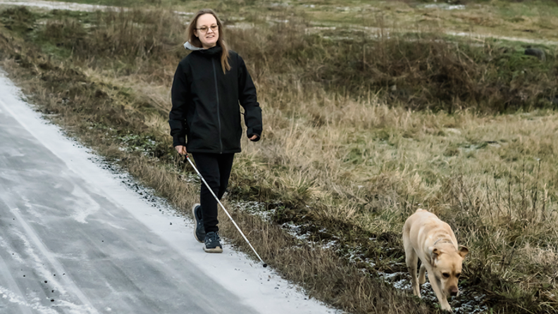 Bussresenär Sofia med sin vita käpp och hund
