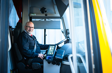 Bussförare Nisse bakom ratten i sin buss